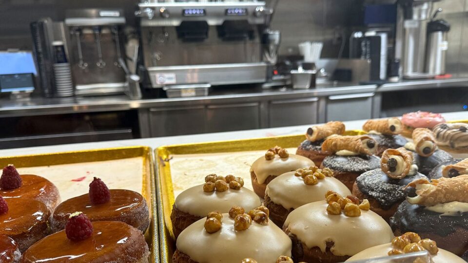 Beautifully Decorated Dougnuts with a coffee machine in the background