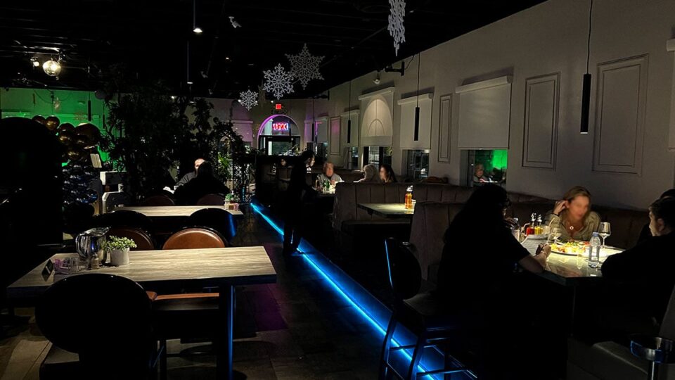 Back dining room with tables and televisions at Beso Restaurant