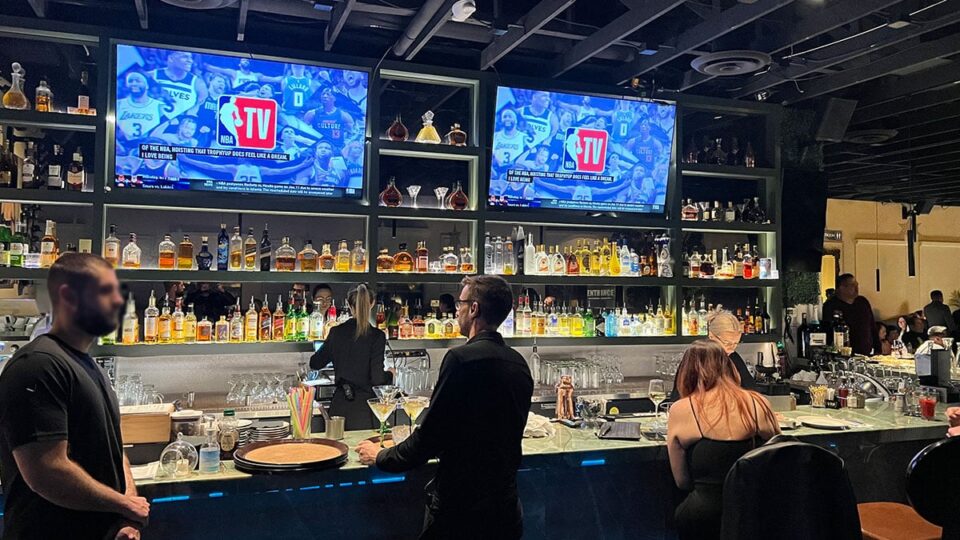 Guests seated at the bar inside Beso Restaurant