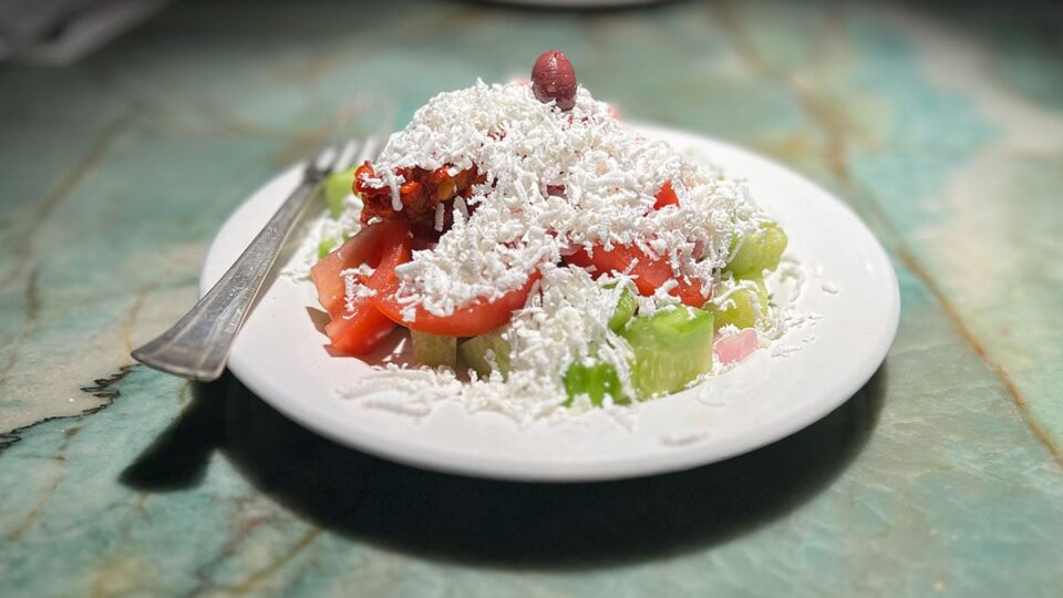 Shopska salad with tomatoes cucumbers peppers onions and cheese at Beso Restaurant