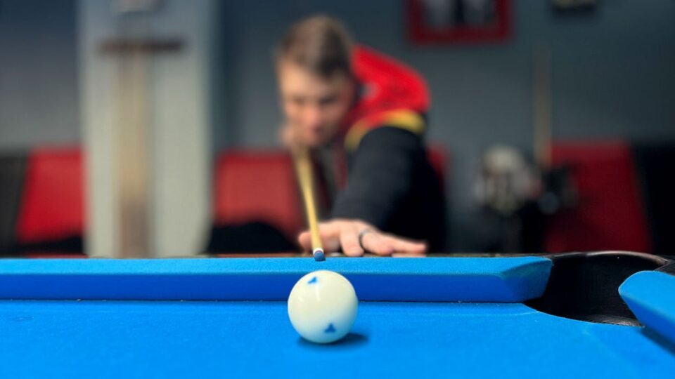 Las Vegas Cue Club - a Player preparing to take a shot at a pool table