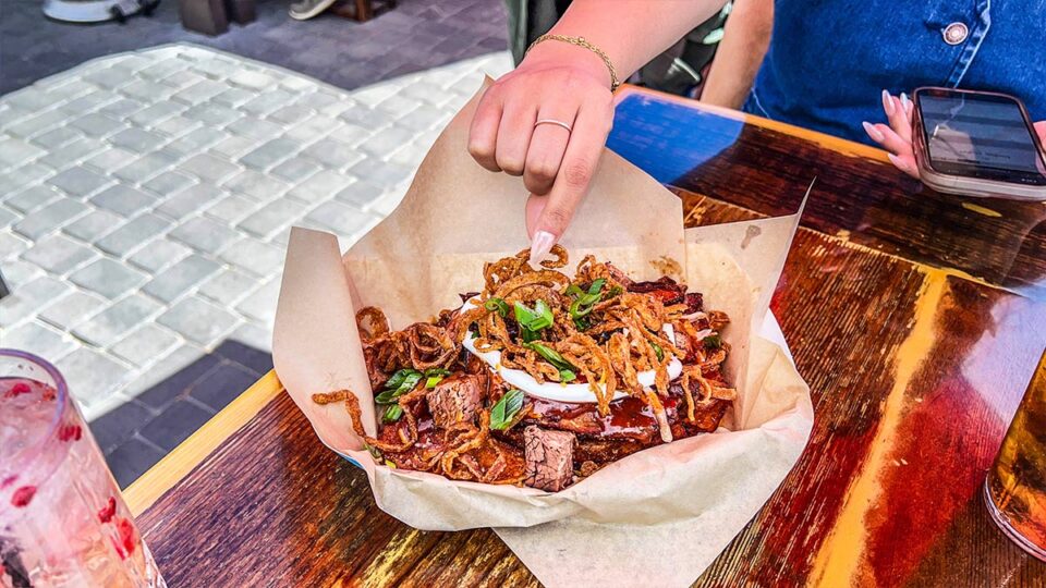 Loaded BBQ Fries at SoulBelly BBQ topped with brisket, cheese, sour cream, BBQ sauce, onions and scallions