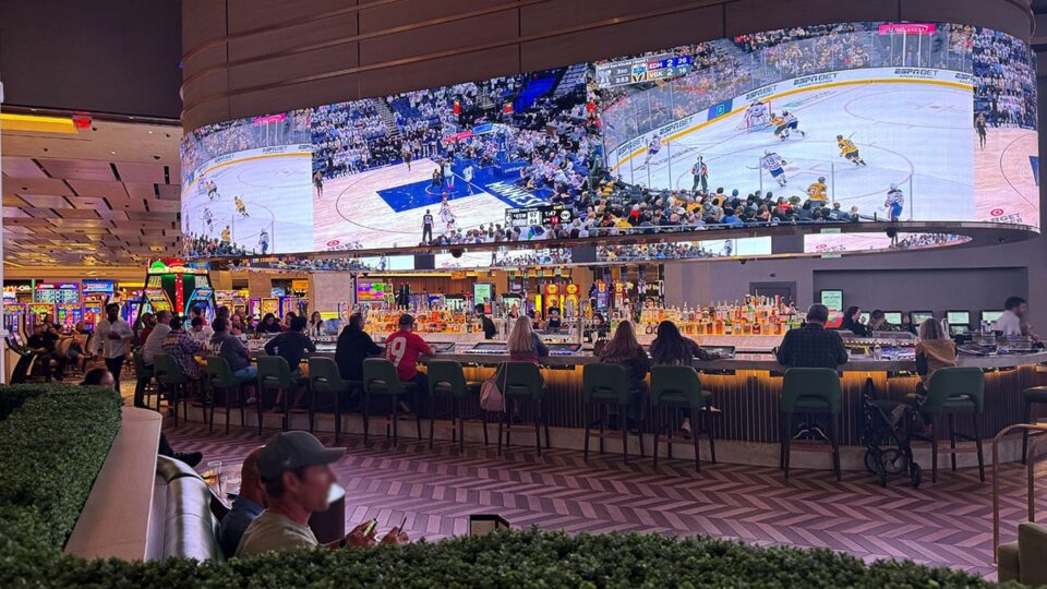 Patrons are drinking, playing, and enjoying the sport events