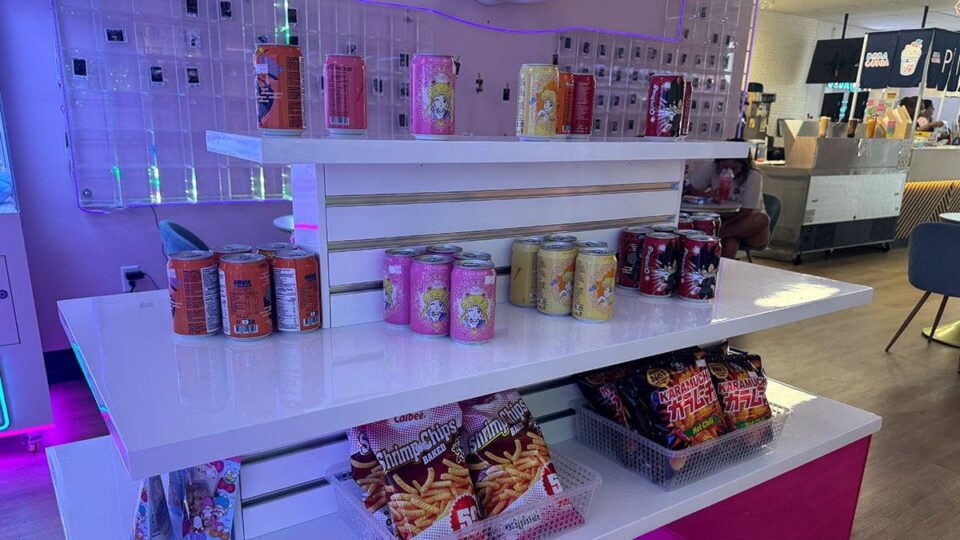 Packaged Asian snacks, candy, chips, and drinks displayed inside Boba CuCue