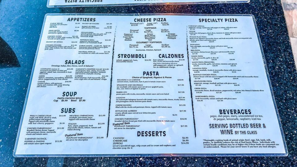 Printed Carmine's Pizza Kitchen menu showing pizza, pasta, calzones, stromboli, and other Italian-American dishes