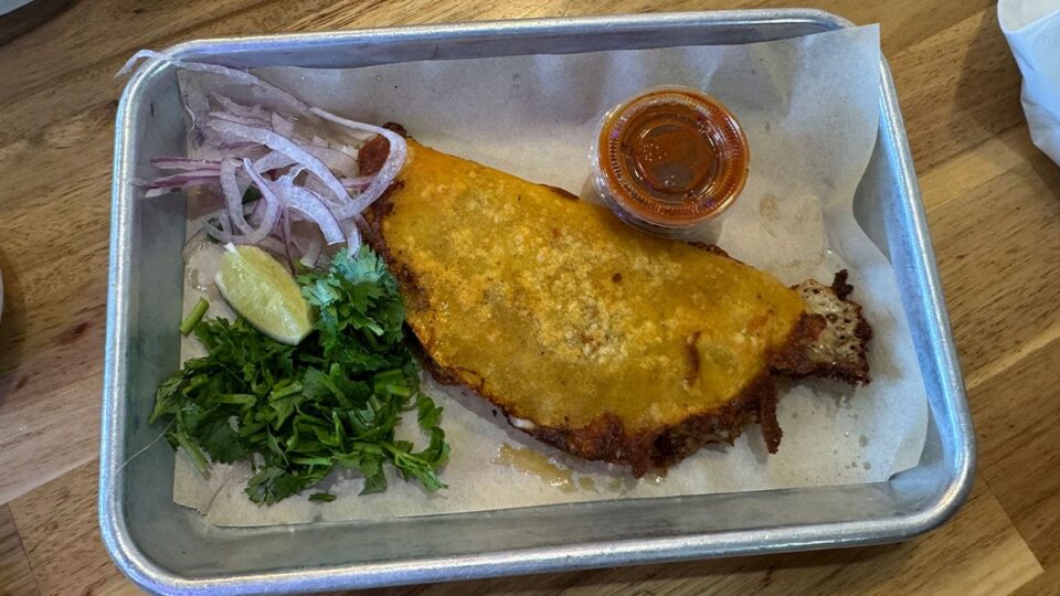 A queso taco filled with slow-braised beef birria