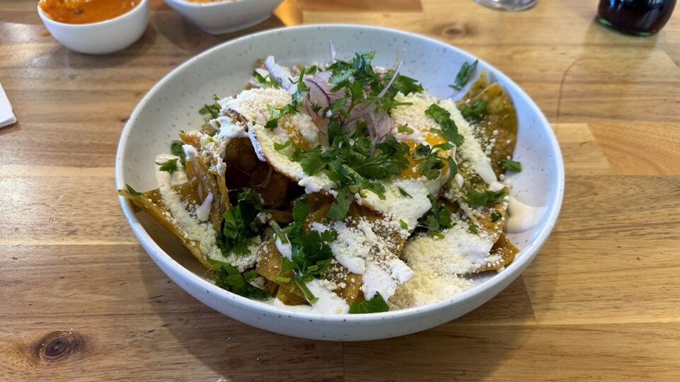 Crispy Chilaquiles at Milpa - corn tortillas coated in salsa, a layer of black beans, and two sunny-side-up eggs