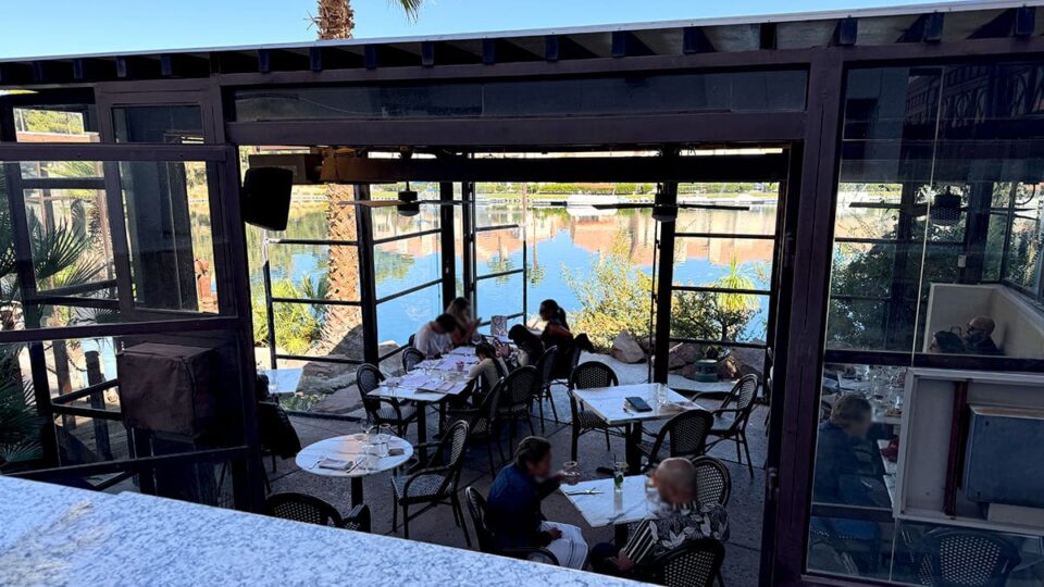 Diners enjoying Sunday brunch on the outdoor patio at Marché Bacchus overlooking Lake Jacqueline.