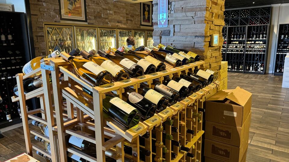 Interior of the Marché Bacchus wine cellar lined with bottles of French and Mediterranean wines.