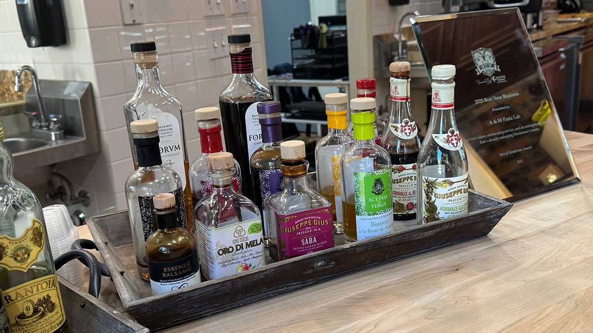 Balsamic vinegar tasting station at A&M Pasta Lab with bottles and sampling cups.