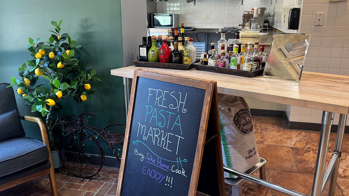 Fresh Pasta Market sign reading “Buy, Take Home, Cook, Enjoy!” at A&M Pasta Lab.
