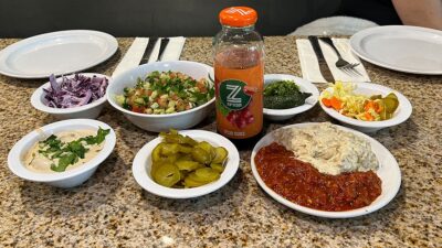 Assortment of fresh salads, tahini, and pita bread served at Shawarma Vegas.