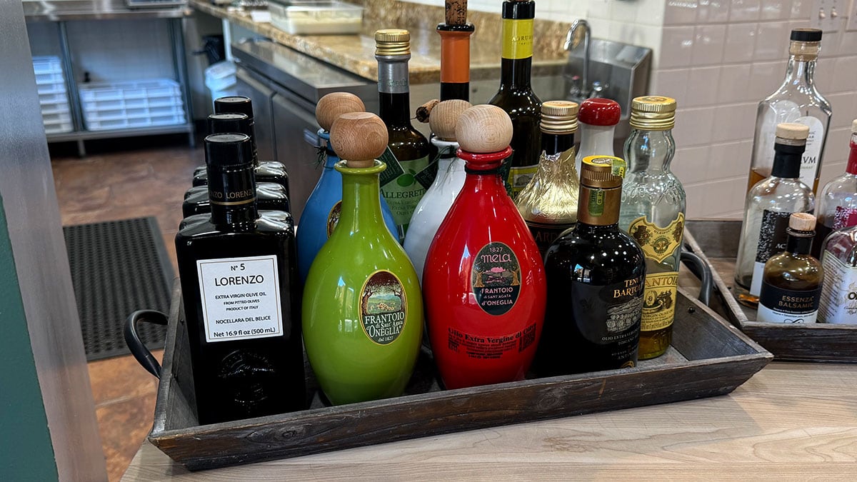 Olive oil tasting station with small cups and Italian bottles at A&M Pasta Lab.