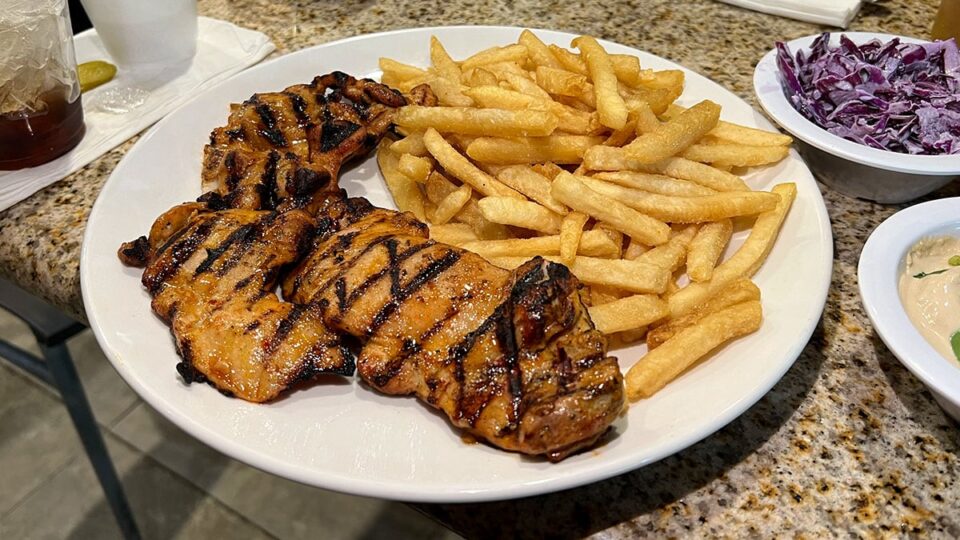 Plate of grilled chicken thigh "pargiot" with a side of fries.