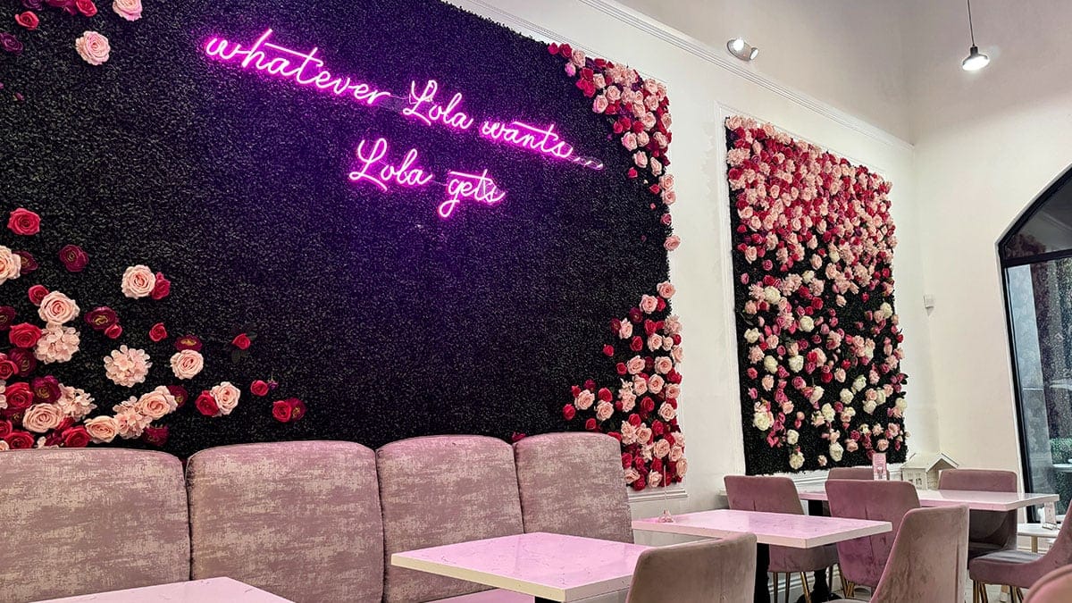 Decorative wall inside Cafe Lola with pastel colors, floral accents, and elegant design details creating a stylish café atmosphere.