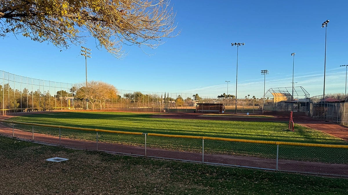 Baseball field at The Trails Park & Pool in Summerlin featuring a grassy field and bleacher seating,