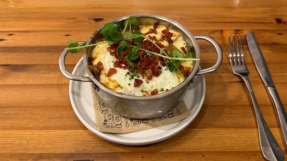 Breakfast poutine with potatoes, bacon gravy, cheese curds, and fried egg at Honey Salt