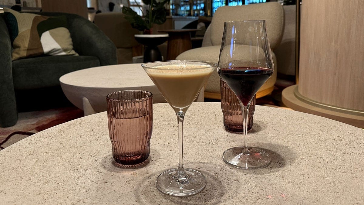 A glass of Pinot Noir alongside a creamy cocktail in a martini glass, highlighting Wineaux’s drink selection and refined presentation.