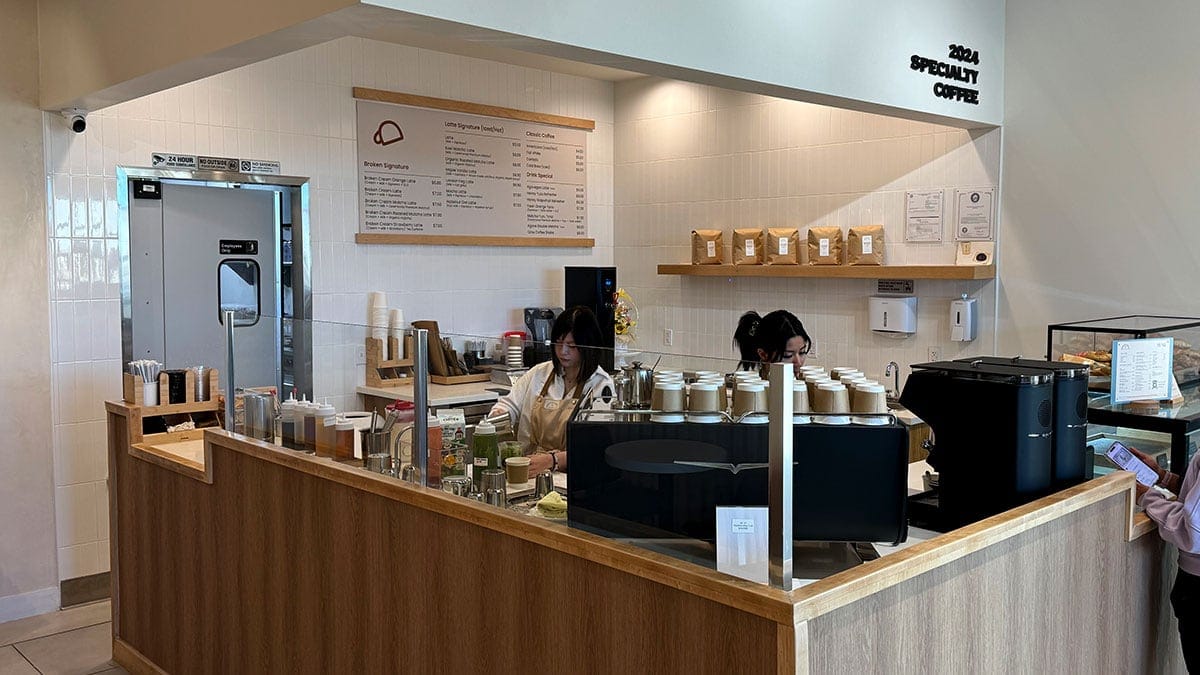 Barista preparing coffee drinks at Broken Coffee during a morning visit.