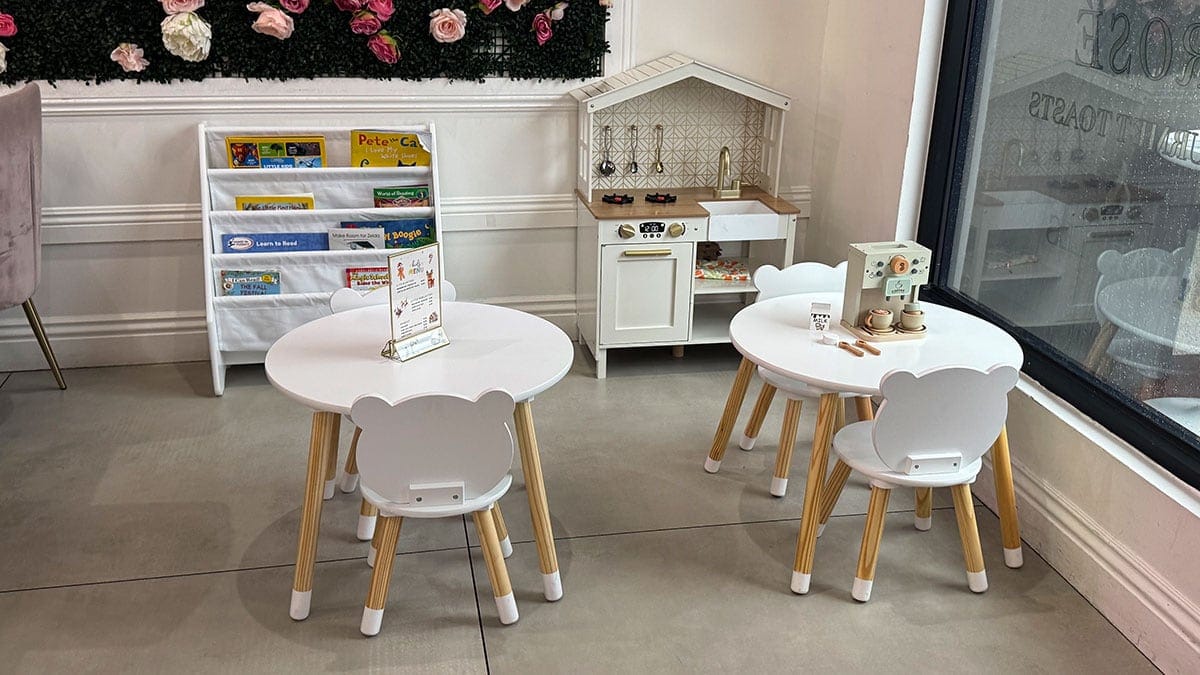 Kids section inside Cafe Lola with small tables and chairs and a playful toy kitchen designed for children to enjoy.
