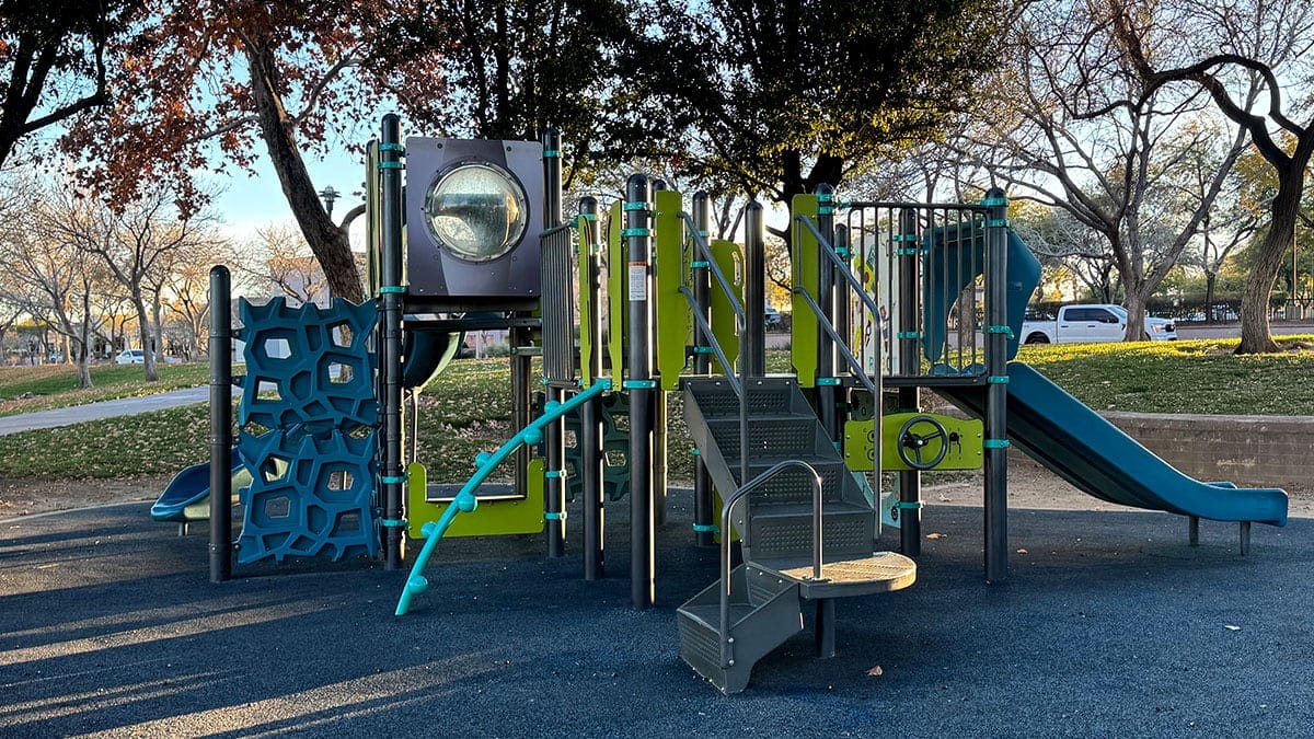 Playground structure at The Trails Park & Pool in Summerlin with slides and climbing features, no people visible.