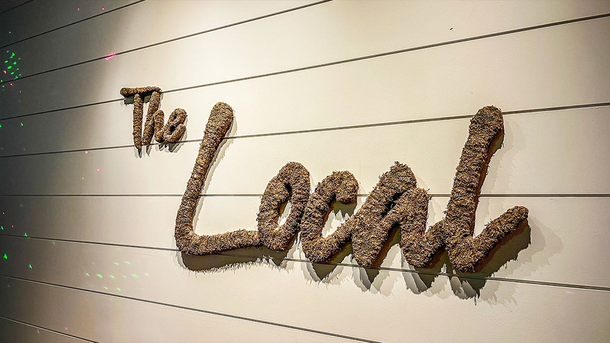 Textured wall sign reading “The Local” inside the wine bar