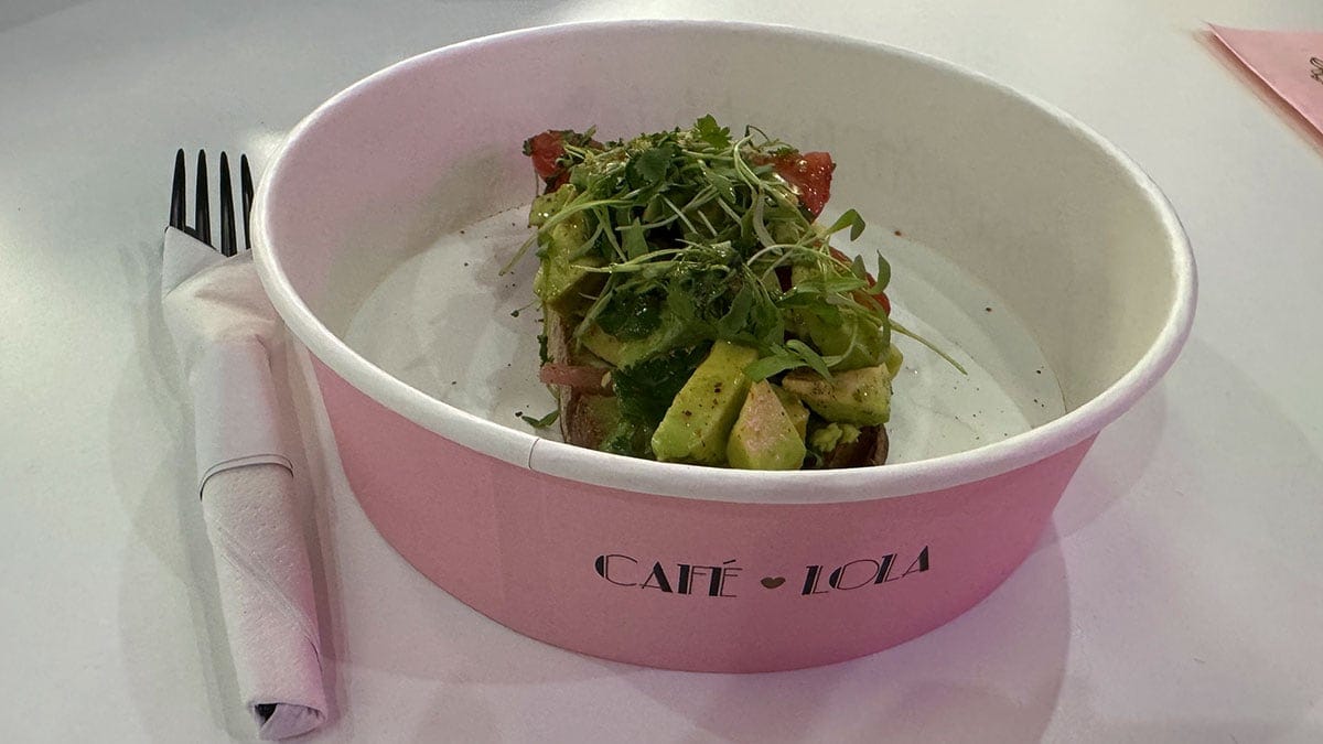 Smashed avocado spread on toasted bread, garnished with fresh toppings and served as a popular café dish.