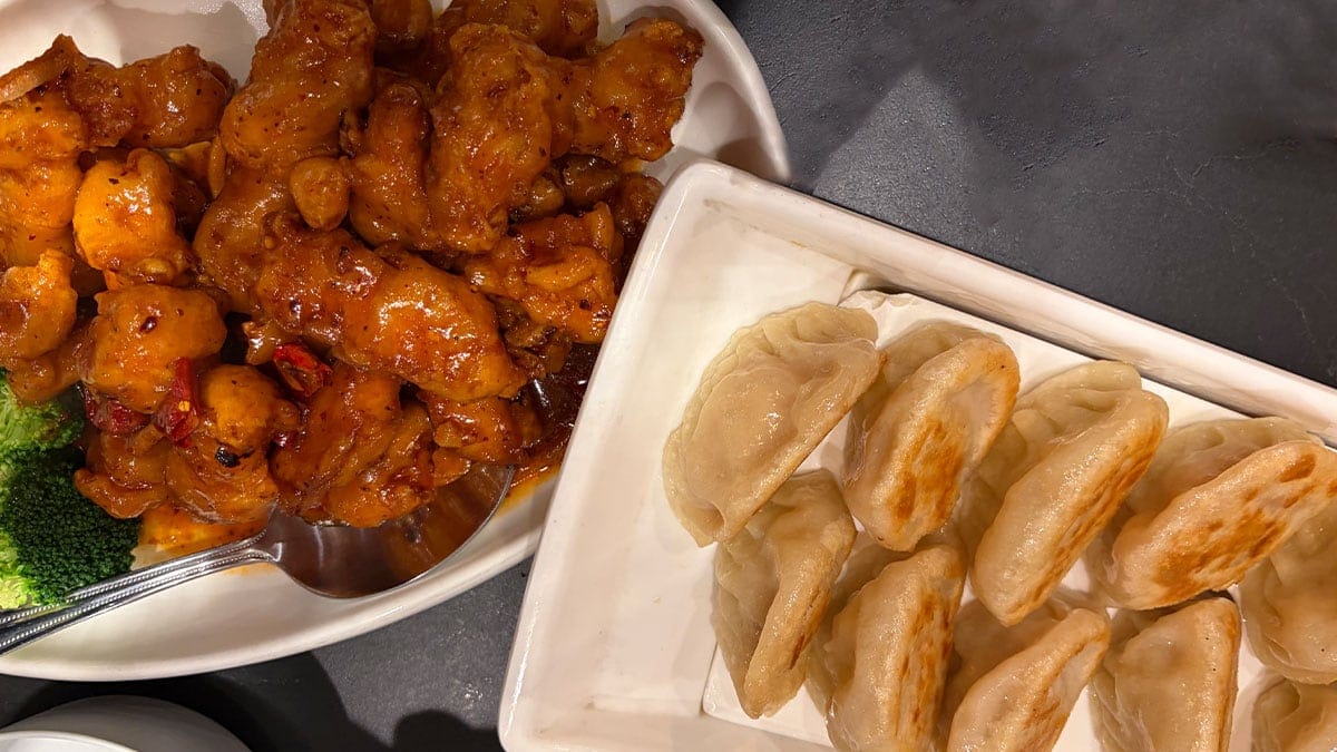 Plate of dumplings and orange chicken from China Mama, served fresh and ready to enjoy.