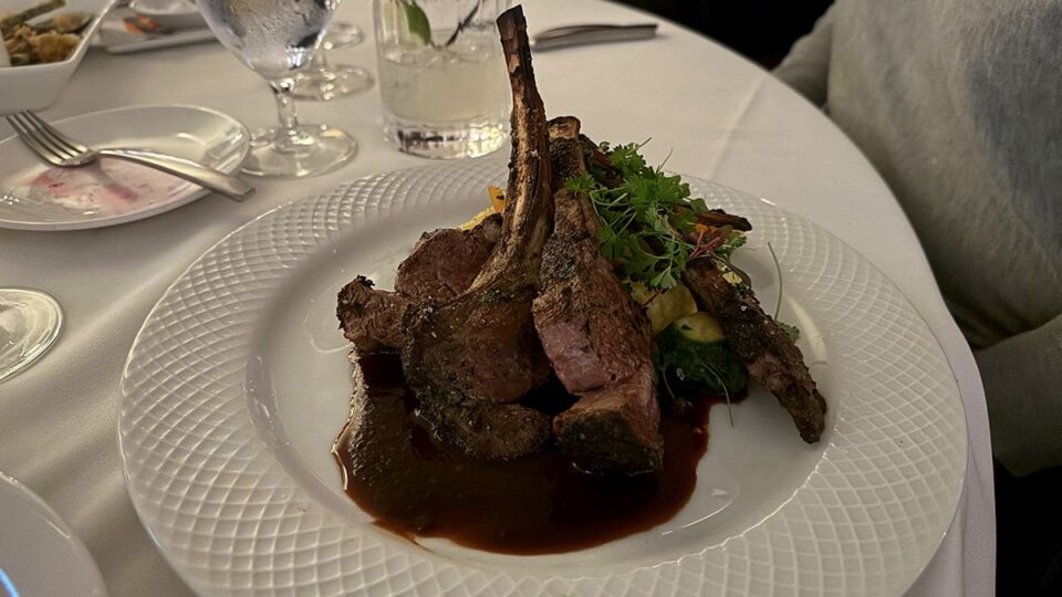 Moroccan-spiced Australian rack of lamb with creamy polenta, baby vegetables, and red wine reduction at Vintner Grill.