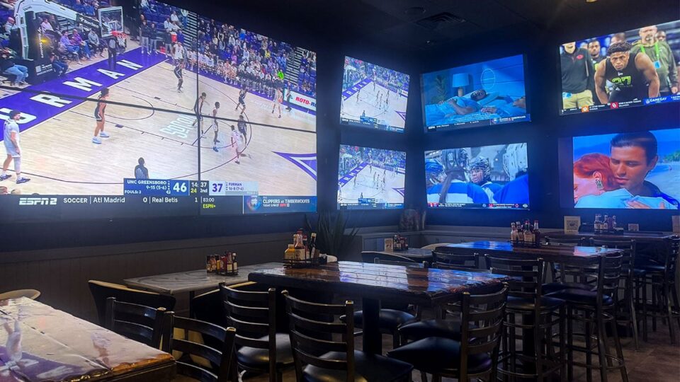 Big screens at Sagos Tavern showing multiple sports events around the bar.