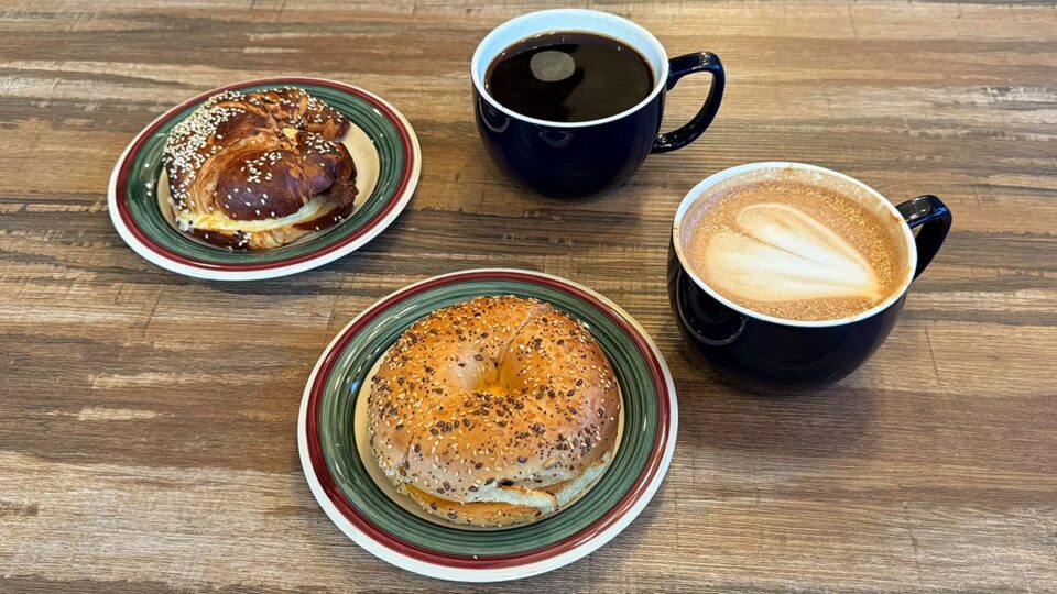 Breakfast bagel and croissant sandwiches served on a table inside Exit Zero Coffee