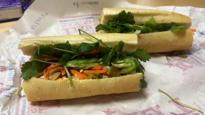 Grilled chicken banh mi sandwich served on a toasted baguette with pickled carrots, daikon, fresh cucumber, cilantro, and spicy mayonnaise.