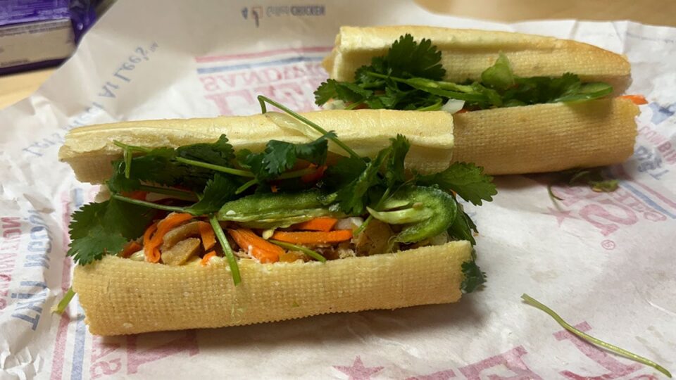 Grilled chicken banh mi sandwich served on a toasted baguette with pickled carrots, daikon, fresh cucumber, cilantro, and spicy mayonnaise.