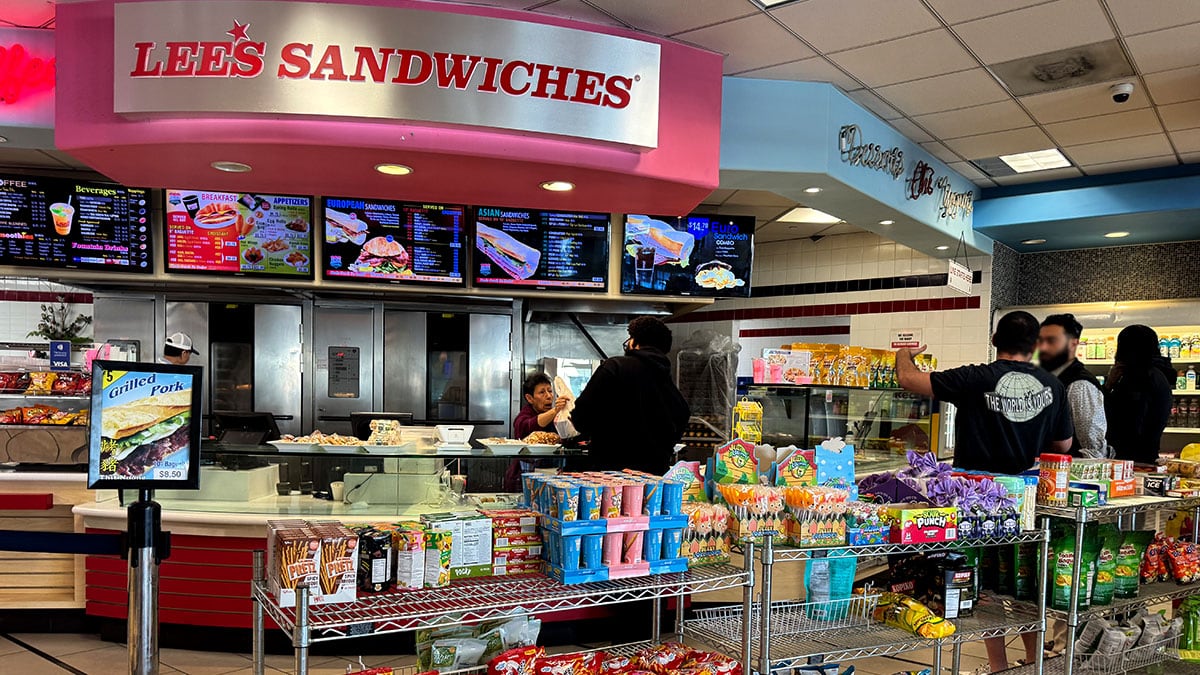 Interior view of the Lee’s Sandwiches counter showing the ordering area and menu boards.