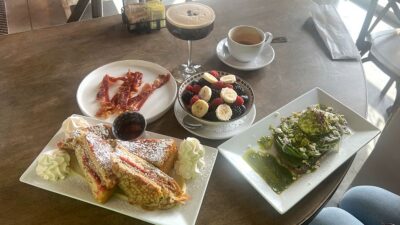 Full brunch spread at Le Café Central in Chinatown Las Vegas featuring PB&J French toast, pesto salmon, fruit, bacon, and coffee.