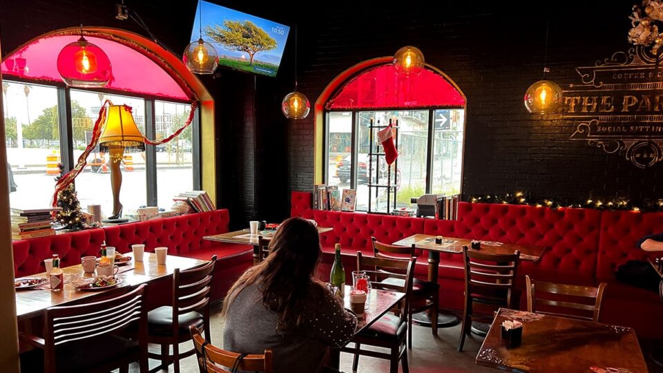 Red tufted booth seating and arched windows inside The Parlour Downtown during brunch.