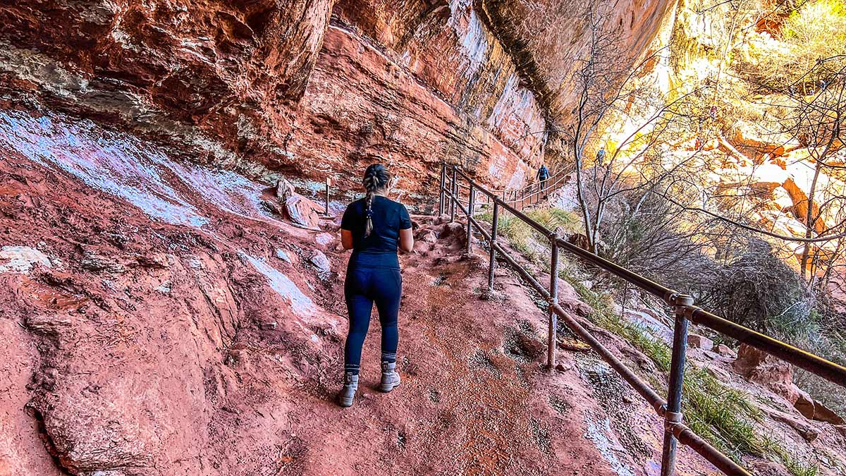 Lower Emerald Pool trail carved into red sandstone with canyon views in the distance.