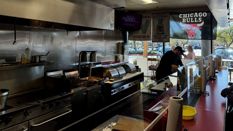 Interior kitchen view at Windy City Beefs-N-Dogs preparing Chicago style hot dogs.