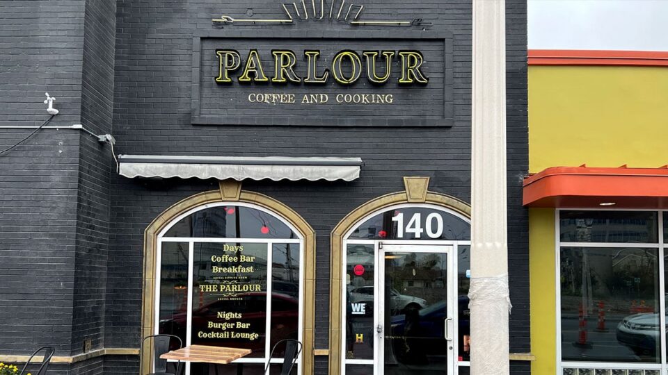 Exterior of The Parlour Coffee and Cooking with the “PARLOUR” sign and entrance number 140.
