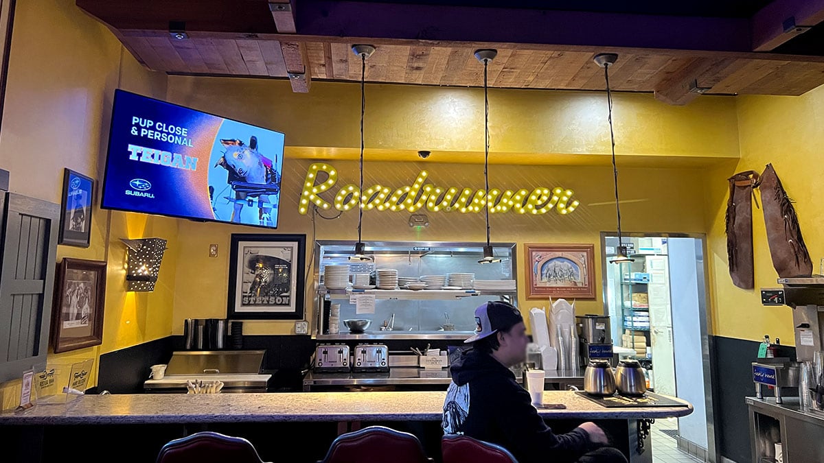 Ordering counter and open kitchen with glowing Roadrunner sign