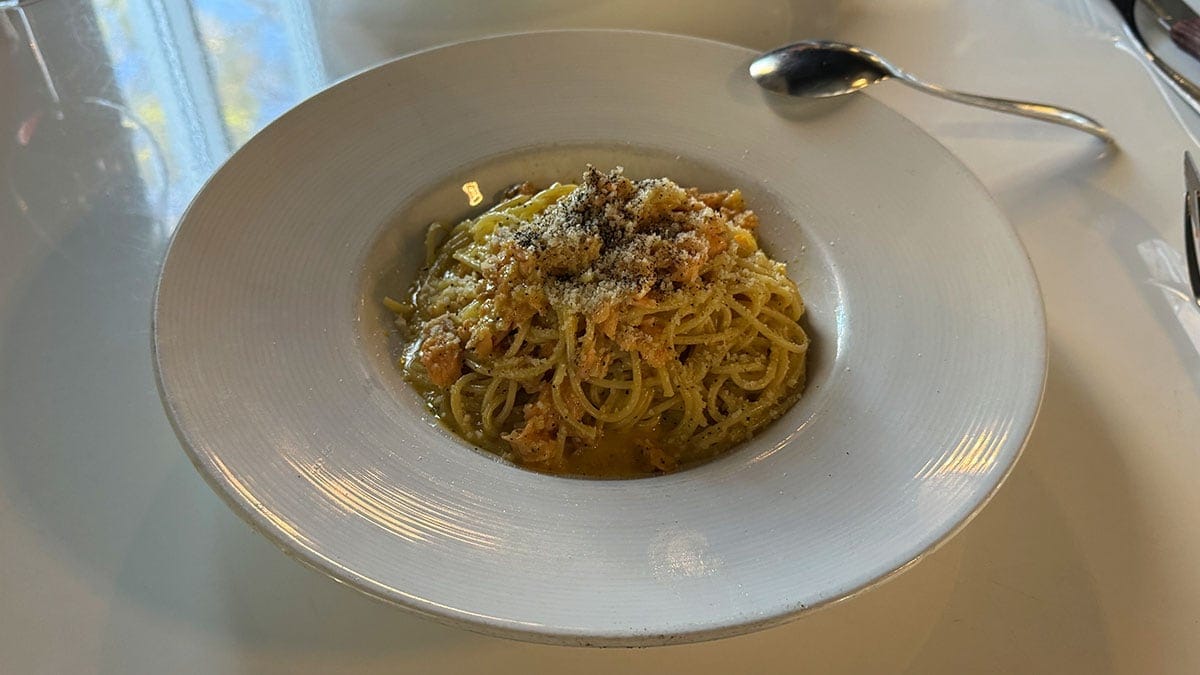 A plate of Salmon Carbonara with spaghetti, salmon, Parmesan, garlic, black pepper, and creamy sauce at Brunello Italian restaurant in Sun City Summerlin.