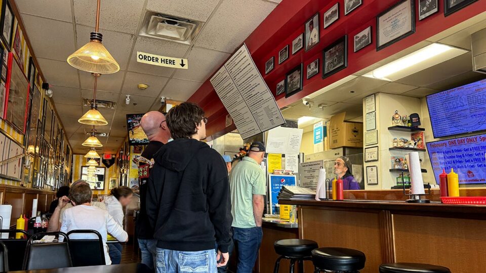 Customers standing in line inside Windy City Beefs-N-Dogs waiting to order.