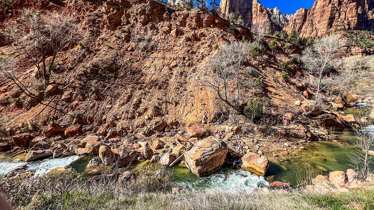 The Virgin River flowing through Zion Canyon beneath towering red rock cliffs.