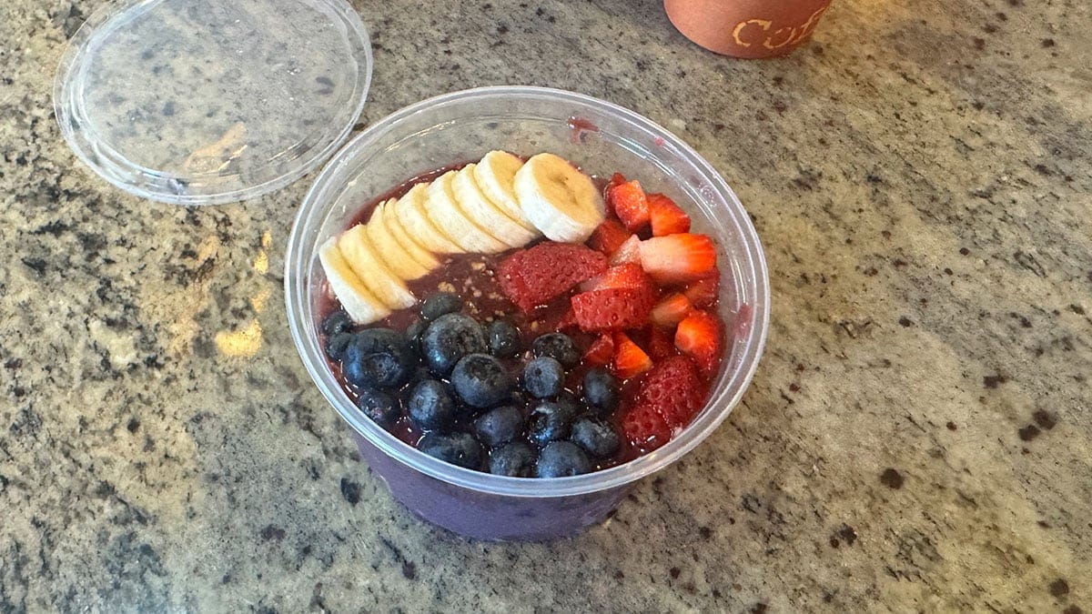 a colorful acai bowl with strawberries, blueberries, banana, and granola