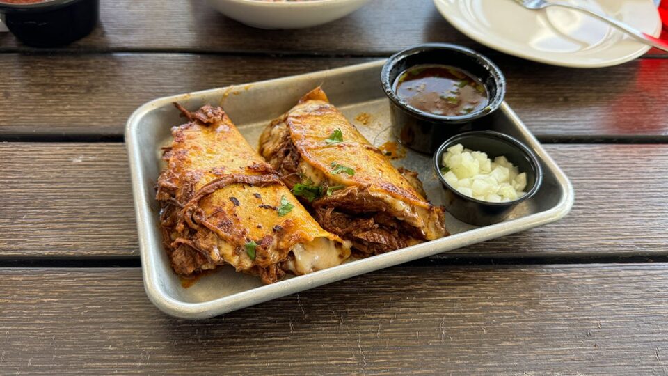 Birria tacos with melted cheese and consommé dipping sauce at Big T’s Cantina