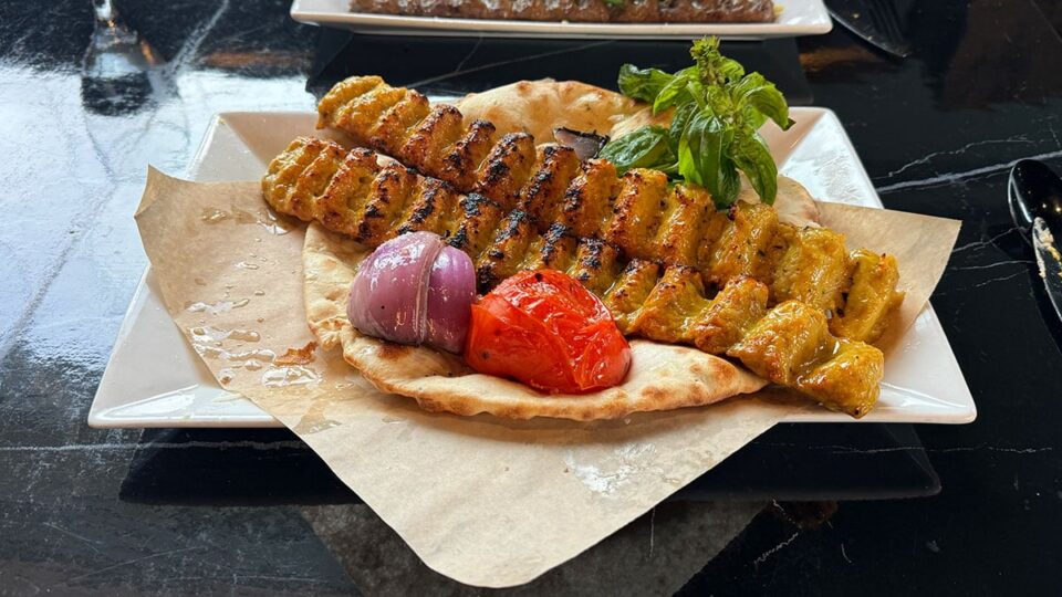 Chicken koobideh served on naan bread with grilled vegetables at Rumi Room
