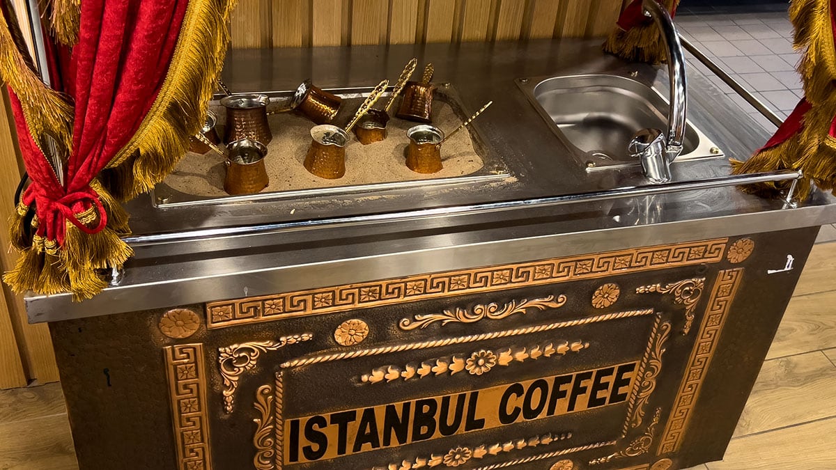 a coffee station setup with turkish coffee equipment and cups inside a restaurant setting