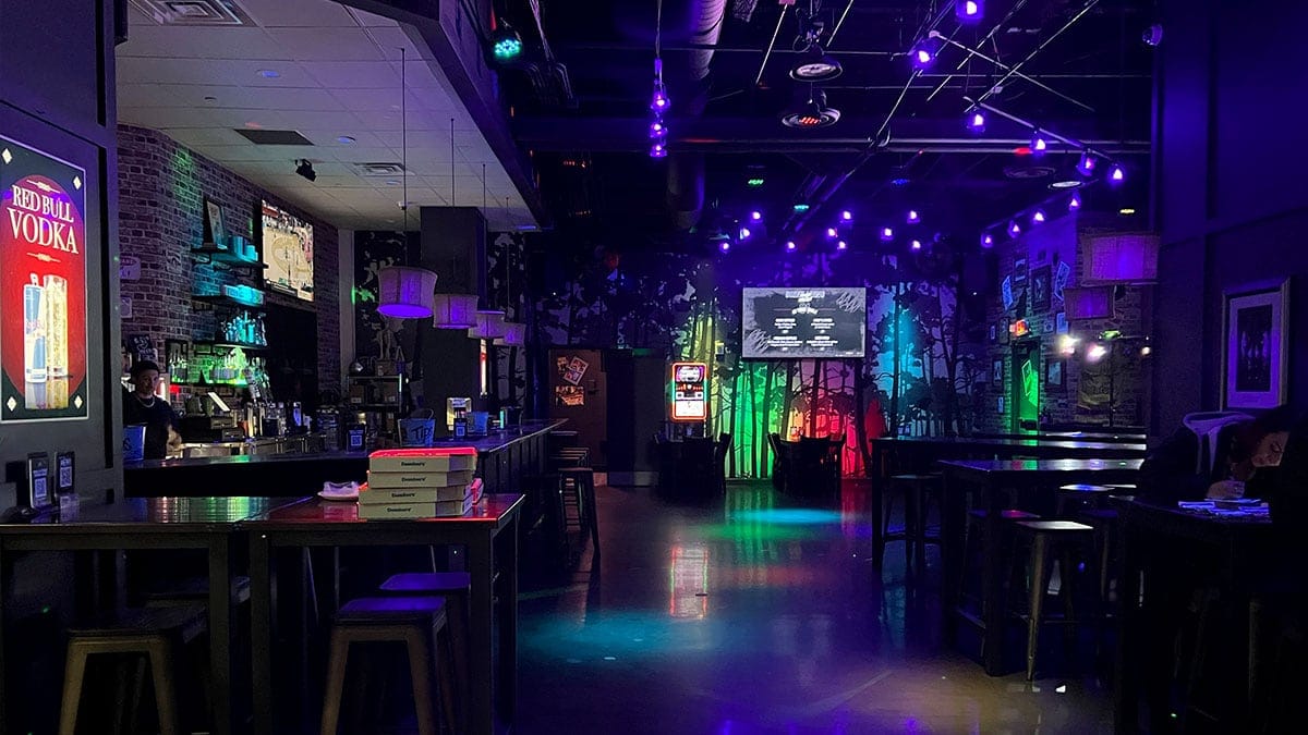 Interior of Raised By Wolves bar showing lively crowd, glowing lights, and downtown party atmosphere.