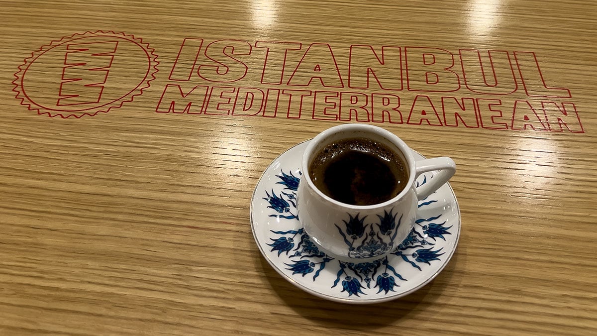 a small cup of traditional turkish coffee served in a decorative cup with thick, dark coffee inside