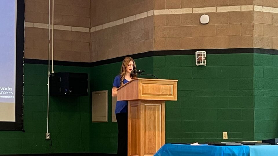 Sophia Booth speaking to volunteers at community service event